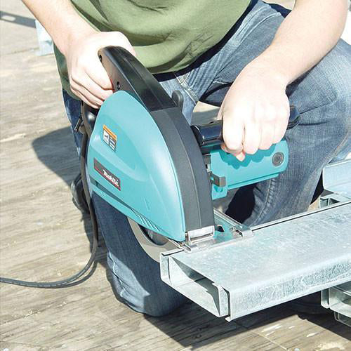 Person using a Makita metal cutter in teal and black colour 