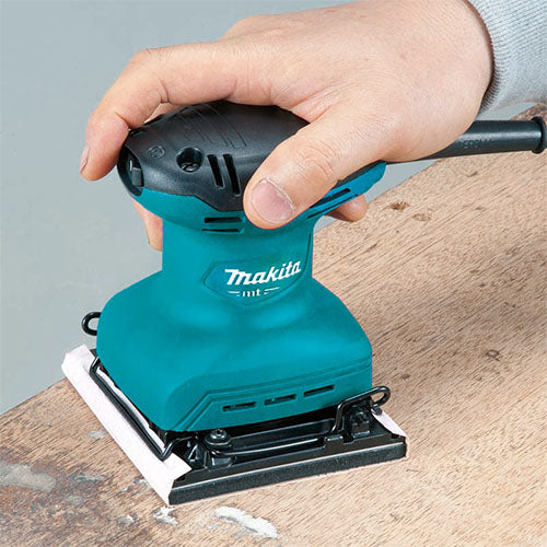 Person using a teal and black Makita Sander on wood