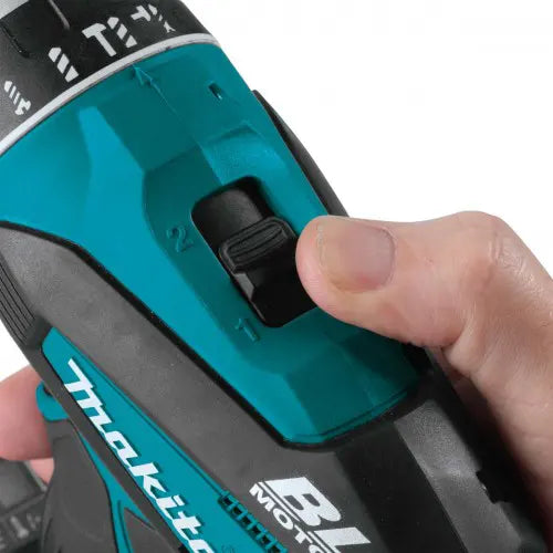 Close-up of a Makita power tool with a hand pressing a button on the side.