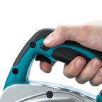 A close-up of a person's hand pressing a button on the handle of a teal and black thickness planer against a white background.