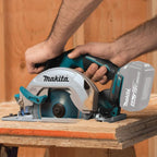 Person using a Makita cordless circular saw on a wooden surface