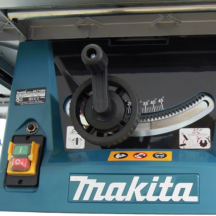 Close-up of a Makita table saw control panel featuring a black handwheel, angle scale markings, a red and green emergency stop button, and the Makita logo on a teal housing.