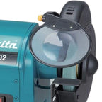 Close-up of a Makita bench grinder showing the teal metal body, black guard, and sanding belt on a white background.