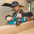 Person using a Makita Cordless Woodshop Planer on a wooden surface