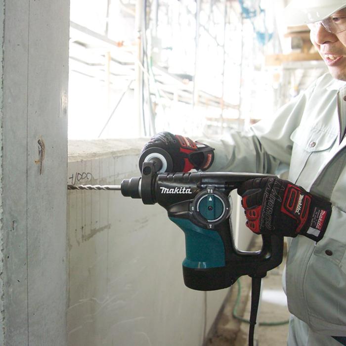 Person using a Makita drill on a construction site