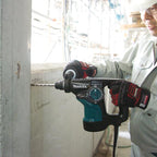 Person using a Makita drill on a construction site